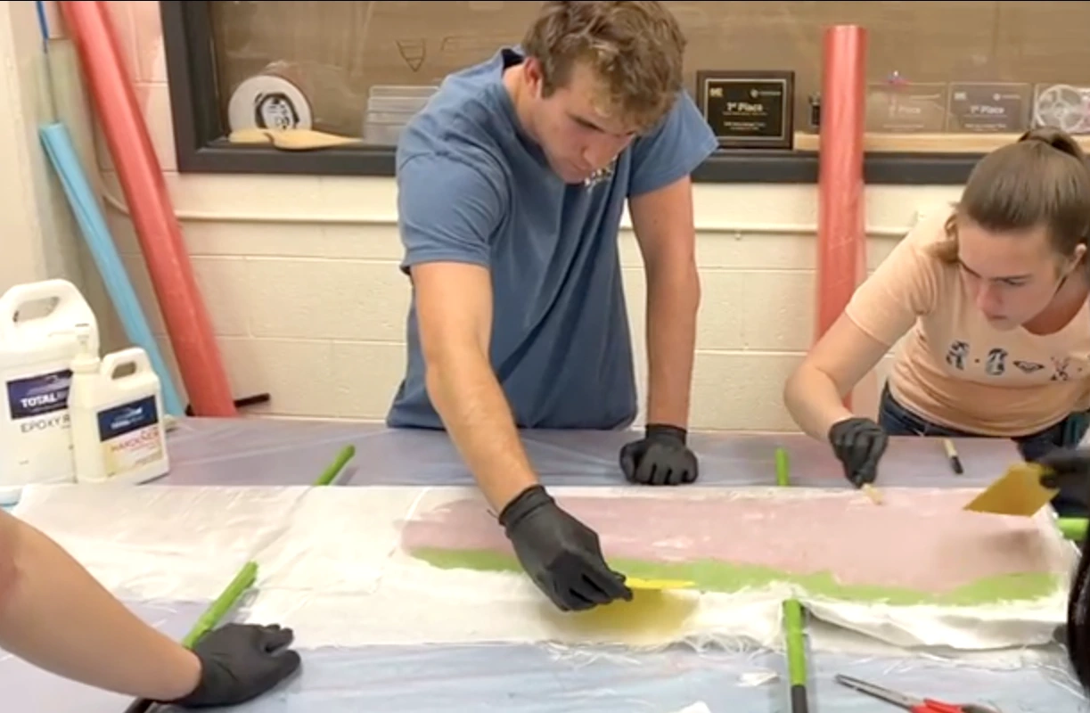 Members fiberglassing pontoons